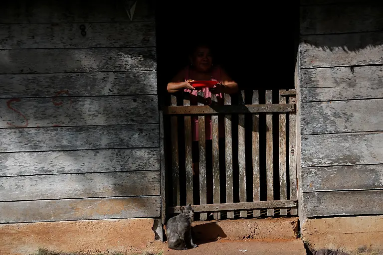 A-woman-looks-out-the-door-of-her-house-in-X-Yatil-Quintana-Roo-state-Mexico-November-11-2025-Mexico-s-1-500-km-Mayan-Train-was-launched-to-drive-development-in-the-country-s-impoverished-south-through-infrastructure-and-tourism-but-two-years-after-its-inauguration-it-is-struggling-financially-ticket-sales-cover-only-a-fraction-of-costs-hotels-remain-largely-empty-and-communities-along-the-route-say-poverty-persists-and-promised-benefits-have-yet-to-materialize-A-Reuters-review-of-census-data-and-interviews-with-residents-along-the-line-found-that-poverty-remains-widespread-and-well-paid-jobs-scarce-despite-the-project-REUTERS-Daniel-Becerril-SEARCH-BECERRIL-MAYA-TRAIN-FOR-THIS-STORY-SEARCH-WIDER-IMAGE-FOR-ALL-STORIES