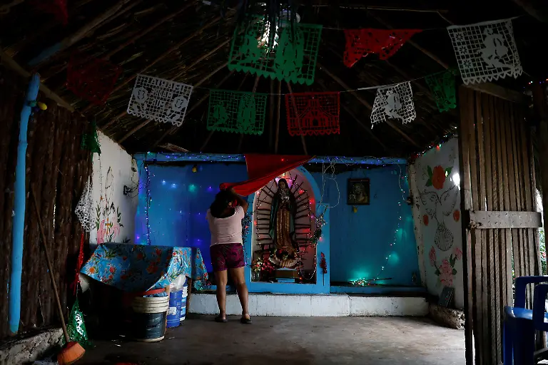 Matilde-Kinil-Pool-53-cleans-the-Virgin-of-Guadalupe-chapel-in-the-courtyard-of-her-home-in-Uh-May-Quintana-Roo-state-Mexico-November-16-2025-Historically-marginalized-Maya-populations-in-Mexico-s-southeast-have-long-faced-high-poverty-rates-and-limited-access-to-services-and-while-the-Mayan-Train-was-promoted-as-a-way-to-bring-development-to-Indigenous-Maya-communities-many-community-activists-say-instead-that-their-forests-have-been-fragmented-communal-lands-eroded-and-traditions-strained-For-many-Maya-the-land-over-which-it-runs-is-their-sacred-inheritance-central-to-their-identity-and-linking-them-to-their-ancestors-REUTERS-Daniel-Becerril-SEARCH-BECERRIL-MAYA-TRAIN-FOR-THIS-STORY-SEARCH-WIDER-IMAGE-FOR-ALL-STORIES