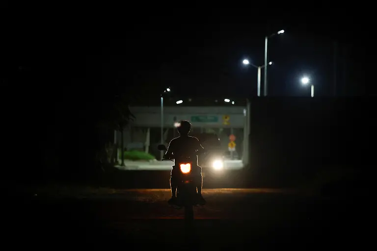 Vehicles-travel-along-a-lit-street-in-the-Vida-y-Esperanza-community-where-electricity-extends-only-as-far-as-the-Maya-Train-service-station-next-to-a-primary-school-that-pays-for-its-own-power-supply-in-Quintana-Roo-state-Mexico-November-10-2025-Teacher-Lidia-Patricia-Chan-Us-has-spent-years-trying-to-get-power-connected-but-the-authorities-have-told-her-electricity-cannot-be-installed-until-the-land-beneath-the-school-has-formal-titles-a-red-tape-issue-common-for-rural-communal-plots-like-this-which-she-had-hoped-might-change-with-the-arrival-of-a-mega-project-that-the-government-had-vowed-would-spur-development-and-progress-At-the-beginning-when-the-project-came-along-we-were-happy-about-it-Chan-Us-said-Some-residents-sold-food-to-construction-workers-which-she-said-was-a-benefit-to-the-community-But-when-the-construction-ended-just-as-quickly-as-it-arrived-it-was-gone-REUTERS-Daniel-Becerril-SEARCH-BECERRIL-MAYA-TRAIN-FOR-THIS-STORY-SEARCH-WIDER-IMAGE-FOR-ALL-STORIES