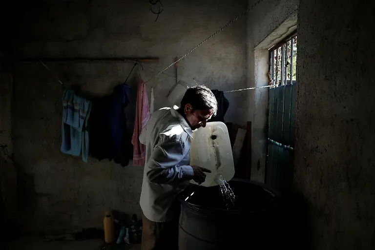 Beekeeper-Nicolas-Moreno-Jimenez-50-pours-drinking-water-he-brought-from-another-community-into-containers-at-his-home-where-residents-face-problems-with-the-drinking-water-supply-in-Xpujil-Campeche-state-Mexico-November-12-2025-Moreno-s-family-was-displaced-decades-ago-when-the-government-created-the-Calakmul-reserve-a-UNESCO-World-Heritage-site-intended-to-protect-biodiversity-and-ruins-of-the-once-mighty-Mayan-empire-where-the-government-has-built-one-of-the-six-Tren-Maya-hotels-We-had-been-there-since-1980-said-Moreno-They-removed-us-in-1993-And-now-they-build-hotels-where-we-could-not-even-stay-REUTERS-Daniel-Becerril-SEARCH-BECERRIL-MAYA-TRAIN-FOR-THIS-STORY-SEARCH-WIDER-IMAGE-FOR-ALL-STORIES