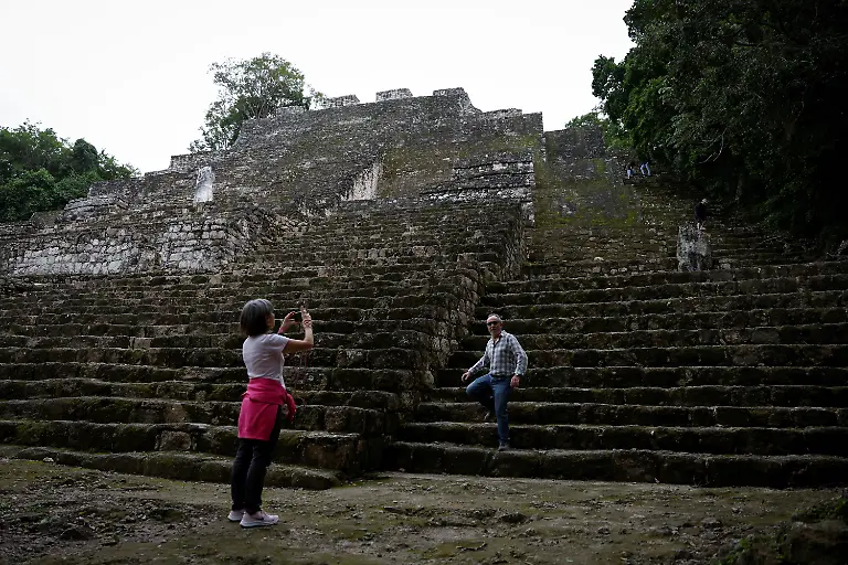 Tourists-take-photos-while-touring-the-pyramids-at-the-Calakmul-archaeological-site-near-the-Tren-Maya-Hotel-built-by-the-military-and-run-by-a-defense-ministry-agency-in-Calakmul-Campeche-state-Mexico-November-13-2025-The-luxury-hotel-is-one-of-six-along-the-train-route-Government-data-reviewed-by-Reuters-shows-those-properties-averaged-monthly-occupancy-rates-between-5-and-24-most-of-last-year-Nicolas-Moreno-Jimenez-a-50-year-old-beekeeper-and-farmer-whose-family-was-displaced-decades-ago-when-the-government-created-the-Calakmul-reserve-a-UNESCO-World-Heritage-site-intended-to-protect-biodiversity-and-ruins-of-the-once-mighty-Mayan-empire-We-had-been-there-since-1980-said-Moreno-They-removed-us-in-1993-And-now-they-build-hotels-where-we-could-not-even-stay-REUTERS-Daniel-Becerril-SEARCH-BECERRIL-MAYA-TRAIN-FOR-THIS-STORY-SEARCH-WIDER-IMAGE-FOR-ALL-STORIES