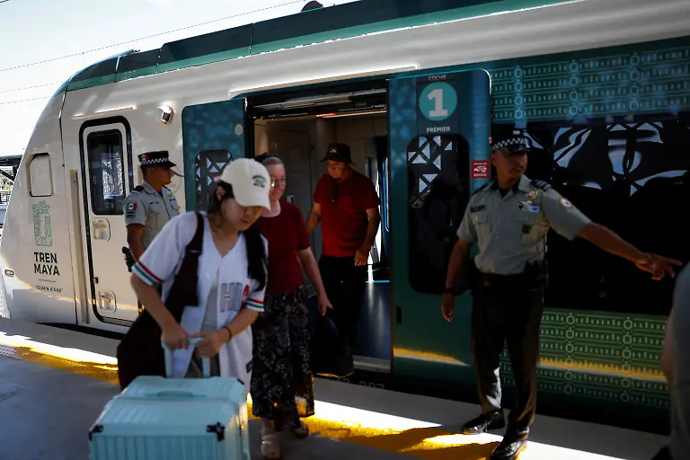 Passengers-get-off-the-Maya-Train-at-the-Bacalar-station-in-Bacalar-Quintana-Roo-state-Mexico-November-12-2025-The-Mayan-Train-has-struggled-to-attract-the-expected-interest-after-legal-challenges-environmental-rerouting-and-land-constraints-pushed-key-segments-inland-leaving-many-stations-far-from-city-centers-and-airports-Reuters-visits-in-November-2025-found-mostly-empty-stations-and-lightly-occupied-trains-as-projected-annual-ridership-was-cut-to-1-2-million-and-the-project-s-cost-swelled-to-more-than-25-billion-with-revenues-covering-less-than-13-of-operating-costs-REUTERS-Daniel-Becerril-SEARCH-BECERRIL-MAYA-TRAIN-FOR-THIS-STORY-SEARCH-WIDER-IMAGE-FOR-ALL-STORIES