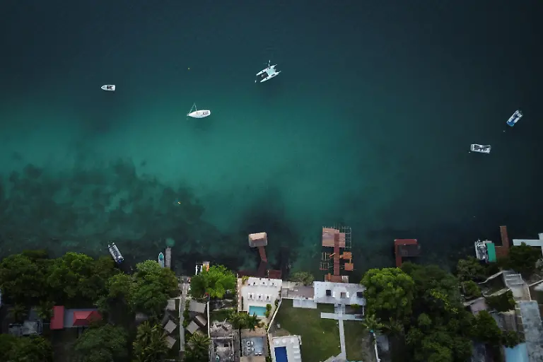 A-drone-view-shows-boats-anchored-in-the-tourist-area-of-Bacalar-Lagoon-in-Bacalar-Quintana-Roo-state-Mexico-November-12-2025-Mexico-s-1-500-km-Mayan-Train-was-launched-to-drive-development-in-the-country-s-impoverished-south-through-infrastructure-and-tourism-but-two-years-after-its-inauguration-it-is-struggling-financially-ticket-sales-cover-only-a-fraction-of-costs-hotels-remain-largely-empty-and-communities-along-the-route-say-poverty-persists-and-promised-benefits-have-yet-to-materialize-A-Reuters-review-of-census-data-and-interviews-with-residents-along-the-line-found-that-poverty-remains-widespread-and-well-paid-jobs-scarce-despite-the-project-REUTERS-Daniel-Becerril-SEARCH-BECERRIL-MAYA-TRAIN-FOR-THIS-STORY-SEARCH-WIDER-IMAGE-FOR-ALL-STORIES