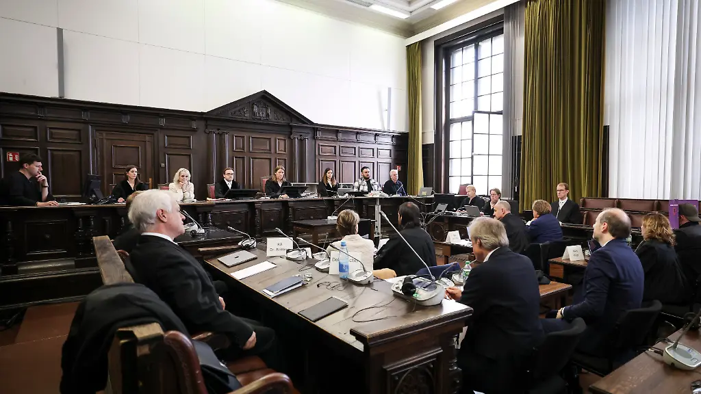 27-04-2026-Hamburg-Richterin-Isabel-Hildebrandt-hinten-5-v-l-Vorsitzende-Richterin-am-Landgericht-und-weitere-Prozessbeteiligte-sitzen-zu-Beginn-eines-weiteren-Prozesstages-im-Prozess-wegen-mutmasslicher-Kindesentfuehrung-im-Gerichtssaal-im-Strafjustizgebaeude-In-einer-Nacht-und-Nebel-Aktion-wurden-in-der-Silvesternacht-2023-24-zwei-Kinder-der-Gastronomie-Unternehmerin-Block-von-Daenemark-nach-Deutschland-gebracht-Wegen-der-mutmasslichen-Entfuehrung-findet-am-Landgericht-Hamburg-der-Prozess-statt-unter-anderem-gegen-Block