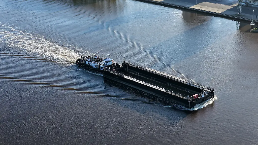 Ein-Lastkahn-geschoben-von-dem-Schubschiff-Hans-faehrt-auf-dem-Nord-Ostsee-Kanal-bei-Hohenhoern-Die-sogenannte-Barge-die-fuer-den-Transport-des-Wals-durch-die-Ostsee-in-die-Nordsee-vorgesehen-ist-soll-kommende-Nacht-oder-Montagfrueh-an-der-Insel-Poel-ankommen