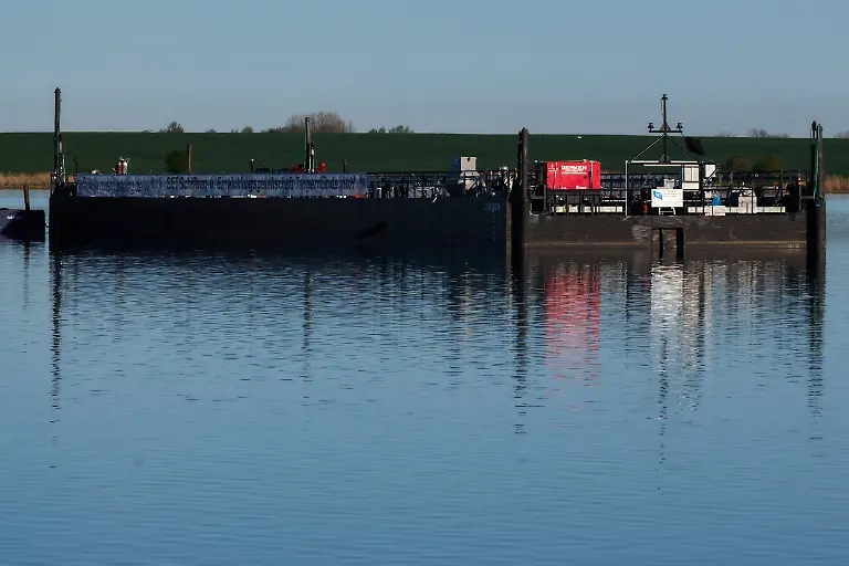 Die-Barge-ein-Lastkahn-steht-fuer-den-gestrandeten-Buckelwal-vor-der-Insel-Poel-bereit-Der-vor-ueber-drei-Wochen-bei-Wismar-gestrandete-Buckelwal-liegt-weiterhin-im-Flachwasser-fest-Eine-private-Initiative-versucht-seit-Tagen-den-Wal-zu-retten