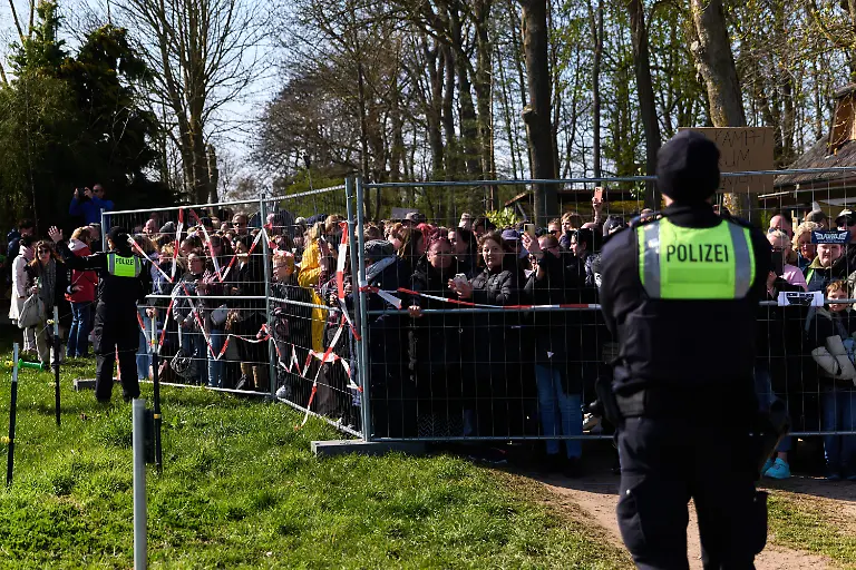 Teilnehmer-einer-Demonstration-fuer-die-Rettung-des-Buckelwals-stehen-hinter-einer-Polizeiabsperrung-Seit-zwoelf-Tagen-treibt-der-verletzte-Wal-in-der-Wismarbucht-vor-der-Insel-Poel-und-zeigt-weiterhin-Lebenszeichen
