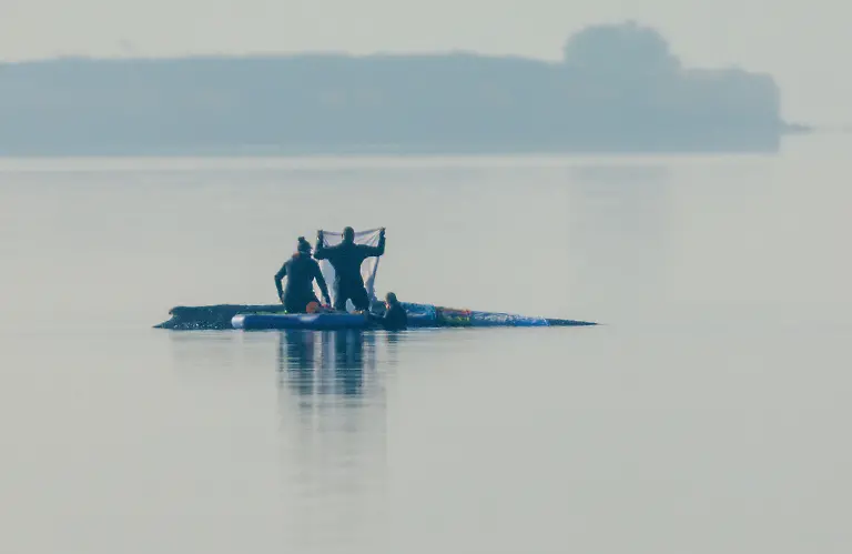 Retter-sind-am-Morgen-in-der-Naehe-des-Buckelwal-vor-der-Insel-Poel-und-legen-Tuecher-auf-dem-Walruecken-aus-Fuer-den-bei-Wismar-gestrandeten-Buckelwal-soll-der-neue-Rettungsversuch-heute-beginnen-Umgesetzt-werden-soll-das-Konzept-von-einer-privaten-Initiative