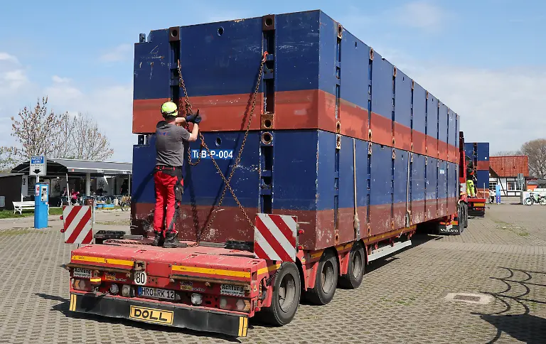 Im-Hafen-von-Kirchdorf-auf-der-Ostseeinsel-Poel-kommen-die-Pontons-zwei-Kraene-und-ein-weiterer-Lastwagen-mit-Technik-fuer-die-Rettung-des-gestrandeten-Buckelwals-an-Fuer-den-vor-der-Insel-Poel-gestrandeten-Buckelwal-beginnt-ein-neuer-Rettungsversuch-Umgesetzt-wird-das-Konzept-von-einer-privaten-Initiative