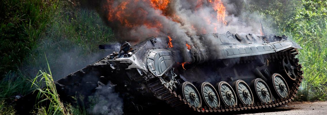 Ein brennender Panzer liegt nach heftigen Kämpfen auf einer Straße in Abidjan.