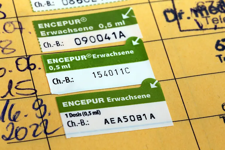Symbolbild-Zeckenimpfung-Aufgeschlagenes-gelbes-Impfbuch-mit-einem-neuen-Eintrag-fuer-eine-Zeckenimpfung-Symbol-image-tick-vaccination-Opened-yellow-vaccination-book-with-a-new-entry-for-a-tick-vaccination