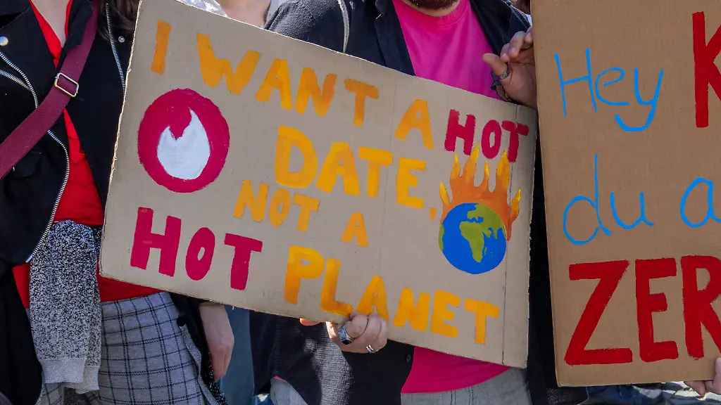 Germany-Bavaria-Augsburg-April-24-2026-Friday-for-Future-demonstration-under-the-slogan-Stop-the-Rich-Save-the-Energy-Transition-Gas-Action-Day-Demonstrators-hold-a-sign-reading-I-want-a-hot-date-not-a-hot-planet-and-another-poster-reading-Hey-Coal-you-old-destroyer-thereby-criticizing-climate-change-and-fossil-fuels-Friday-for-Future-Demo-unter-dem-Motto-Reiche-Stoppen-Enerergiewende-Retten-Gas-Aktionstag-Demonstrierende-halten-ein-Schild-mit-der-Aufschrift-I-want-a-hot-date-not-a-hot-planet-sowie-ein-weiteres-Plakat-Hey-Kohle-du-alter-Zerstoerer-und-kritisieren-damit-Klimawandel-und-fossile-Energien