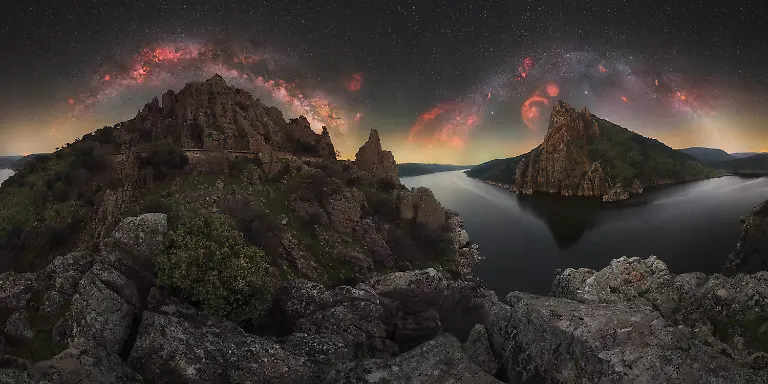 I-am-always-drawn-to-traveling-to-remarkable-natural-landscapes-to-capture-their-essence-through-night-photography-This-image-which-represented-a-significant-challenge-for-me-was-taken-in-Monfraguee-National-Park-during-one-of-the-few-nights-of-the-year-when-both-the-winter-and-summer-Milky-Way-can-be-seen-in-the-same-sky-The-scene-does-not-appear-this-way-to-the-naked-eye-It-is-a-composite-that-captures-the-transition-of-the-Milky-Way-over-several-hours-combining-the-winter-Milky-Way-visible-after-dusk-with-the-summer-Milky-Way-rising-before-dawn-The-following-morning-I-was-able-to-return-to-this-location-with-my-family-who-had-accompanied-me-in-the-search-for-this-long-envisioned-image-Those-shared-moments-along-with-the-effort-behind-the-capture-make-this-photograph-especially-meaningful-to-me
