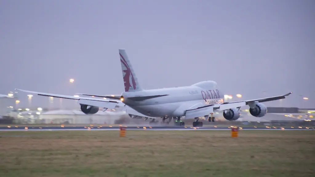 Qatar-Airways-Cargo-Boeing-747-8F-freight-variant-aircraft-as-seen-landing-at-Amsterdam-Schiphol-Airport-AMS-EHAM-in-the-evening-The-quad-jet-Boeing-747-jumbo-jet-a-wide-body-airplane-with-the-registration-A7-BGA-Qatar-Airways-Cargo-the-airline-s-freight-branch-is-the-world-s-third-largest-international-cargo-carrier-QTR-airline-is-the-state-owned-flag-carrier-of-Qatar-with-headquarters-in-Doha-Cargo-flights-have-increased-demand-and-fly-more-as-the-passenger-aviation-industry-traffic-is-phasing-a-difficult-period-with-the-Covid-19-coronavirus-pandemic-having-a-negative-impact-on-the-travel-business-industry-with-fears-of-the-worsening-situation-due-to-the-new-Omega-variant-mutation