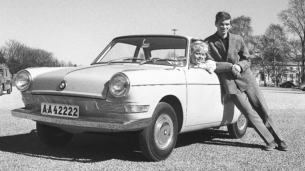 In-den-1960er-Jahren-Die-modisch-gekleidete-Frau-in-ihrem-Auto-einem-BMW-an-einem-sonnigen-Fruehlingstag-Es-ist-die-Schauspielerin-Christina-Schollin-vor-dem-Sjoehistoriska-museet-in-Stockholm-Ihr-Ehemann-Hans-Wahlgren-lehnt-sich-an-das-Auto-Schweden-1962-Kristoffersson-ref-CT84-2-In-the-1960s-The-fashionable-dressed-woman-in-her-car-a-BMW-on-a-sunny-spring-day-She-is-actress-Christina-Schollin-outside-Sjoehistoriska-museet-in-Stockholm-Her-husband-Hans-Wahlgren-is-leaning-against-the-car-Sweden-1962-Kristoffersson-ref-CT84-2-Copyright-imageBROKER-Sjoberg-ibljsj14377767