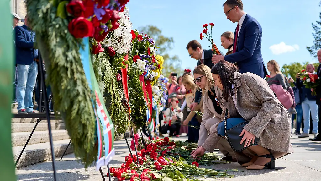 Menschen-haben-rote-Blumen-niedergelegt