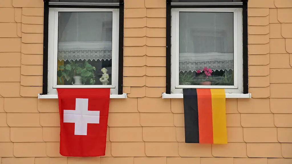 Eine-deutsche-und-eine-Schweizer-Flagge-haengen-am-Dienstag-02-02-2010-in-Klingenthal-Sachsen-am-Fenster-eines-Hauses-Fuer-den-Skisprung-Weltcup-haben-die-Einwohner-des-Ortes-die-Haeuser-geschmueckt-Der-Kauf-gestohlener-Bankdaten-ueber-deutsche-Steuersuender-in-der-Schweiz-ist-nach-Worten-von-Finanzminister-Schaeuble-CDU-beschlossene-Sache-Bei-Schweizer-Grossbanken-waechst-in-der-Steueraffaere-die-Nervositaet