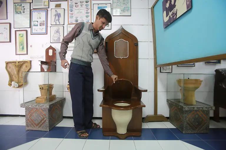epa03956305-An-attendant-shows-a-replica-of-a-rumble-throne-of-a-French-monarch-displayed-at-the-Sulabh-international-toilet-museum-in-New-Delhi-India-19-November-2013-The-museum-traces-the-5-000-year-history-of-toilets-and-aims-to-educate-people-about-the-health-and-social-aspects-of-sanitation-November-19-is-marked-as-the-World-Toilet-Day