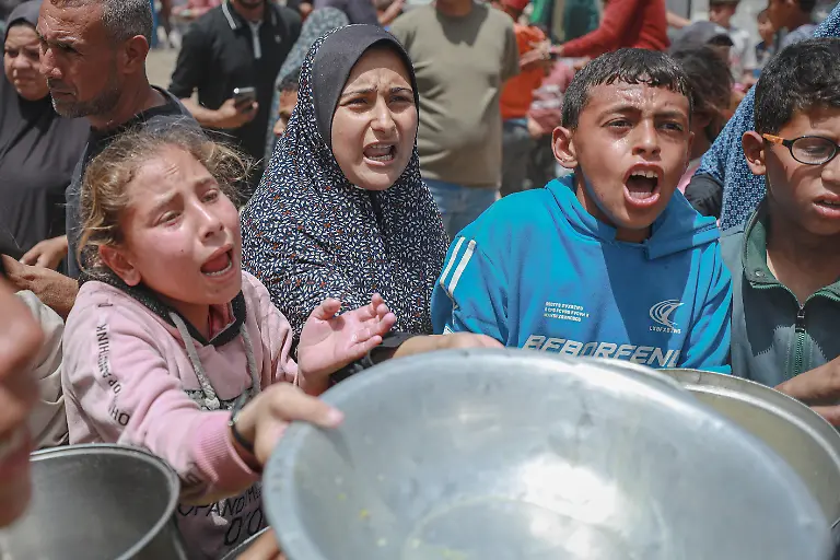 GAZA-CITY-GAZA-PALESTINE-MAY-12-Displaced-Palestinian-families-including-many-children-wait-in-long-queues-with-containers-to-receive-cooked-meals-distributed-by-a-charity-organization-in-Gaza-City-Gaza-Palestine-on-May-12-2026-As-the-Israeli-blockade-and-restrictions-on-aid-entries-continue-to-cause-severe-food-shortages-throughout-the-Gaza-Strip-local-and-international-charities-have-become-a-primary-lifeline-for-thousands-of-people-living-in-makeshift-shelters-Hamza-Z-H