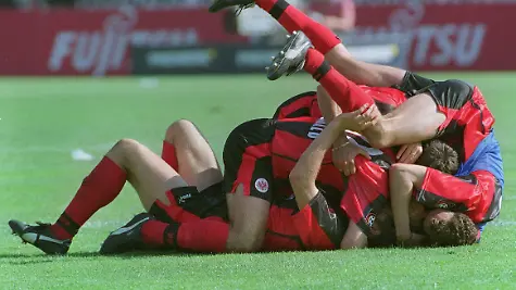 ARCHIV-Ein-Knaeuel-Frankfurter-Spieler-jubelt-nach-dem-5-1-Sieg-der-Eintracht-gegen-den-1-FC-Kaiserslautern-am-29-05-1999-im-Frankfurter-Waldstadion-Die-Frankfurter-schafften-den-Klassenerhalt-durch-eine-gleichzeitige-Niederlage-des-1-FC-Nuernberg-gegen-den-SC-Freiburg-Durch-den-vierten-Frankfurter-Sieg-in-Serie-wurde-das-Fussball-Wunder-wahr-gemacht-Foto-Katja-Lenz-dpa-zu-dpa-Meldung-Joerg-Berger-und-die-Titanic-Frankfurts-wundersame-Rettung-1999-vom-22-05