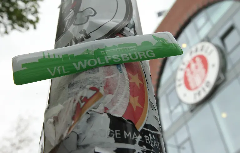 Ein-Aufkleber-des-Fussball-Bundesligisten-VfL-Wolfsburg-wurde-an-einem-Strassenschild-auf-dem-Harald-Stender-Platz-vor-dem-Millerntor-Stadion-des-FC-St-Pauli-befestigt-Die-Woelfe-koennen-am-Sonnabend-mit-einem-Sieg-im-Millerntor-Stadion-Relegationsplatz-16-sichern-und-damit-den-ersten-Bundesliga-Abstieg-in-der-Vereinsgeschichte-zumindest-vorerst-verhindern-Symbolbild-Symbolfoto-St