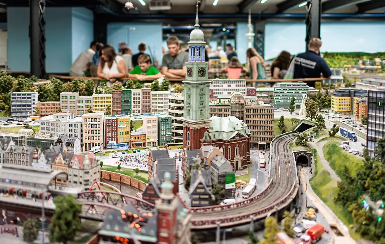 Besucher-betrachten-ein-Modell-im-Miniaturwunderland-hier-das-Hamburger-Wahrzeichen-den-Michel