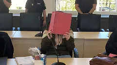 Die-30-jaehrige-Angeklagte-im-Fall-Fabian-in-Rostock-haelt-sich-im-Gericht-einen-Ordner-vors-Gesicht-Vor-dem-Rostocker-Landgericht-ist-der-Prozess-gegen-eine-30-jaehrige-Frau-fortgesetzt-worden-die-im-Oktober-2025-den-achtjaehrigen-Fabian-aus-Guestrow-getoetet-haben-soll