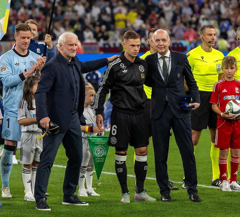04-06-2025-Fussball-UEFA-Nations-League-2024-25-Halbfinale-Deutschland-Portugal-in-der-Allianz-Arena-Muenchen-Joshua-Kimmich-mitte-FC-Bayern-Muenchen-bekommt-eine-Ehrung-fuer-100-Laenderspiele-von-Sportdirektor-Rudi-Voeller-li-Deutschland-und-DFB-Praesident-Bernd-Neuendorf-re-Deutschland-li-Jonathan-Tah-Deutschland-Torwart-Marc-Andre-ter-Stegen-Deutschland-dahinter-mit-dem-gruenen-DFB-Wimpel-der-Sohn-von-Kimmich-der-ueberraschend-fuer-den-Papa-als-Einlaufkind-ausgewaehlt-wurde