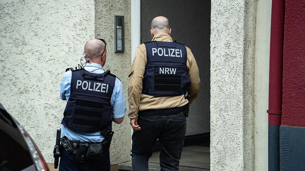 Polizisten-stehen-vor-einem-Hauseingang-Ein-mutmasslich-der-Reichsbuerger-Szene-angehoerender-Mann-ist-in-Wuppertal-von-der-Polizei-festgenommen-worden