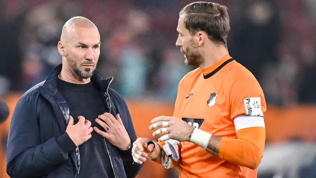 ARCHIV-10-04-2026-Bayern-Augsburg-Fussball-Maenner-Bundesliga-FC-Augsburg-TSG-1899-Hoffenheim-29-Spieltag-WWK-Arena-Trainer-Christian-Ilzer-1899-Hoffenheim-und-Torwart-Oliver-Baumann-1899-Hoffenheim-reagieren-nach-dem-Spiel-unzufrieden
