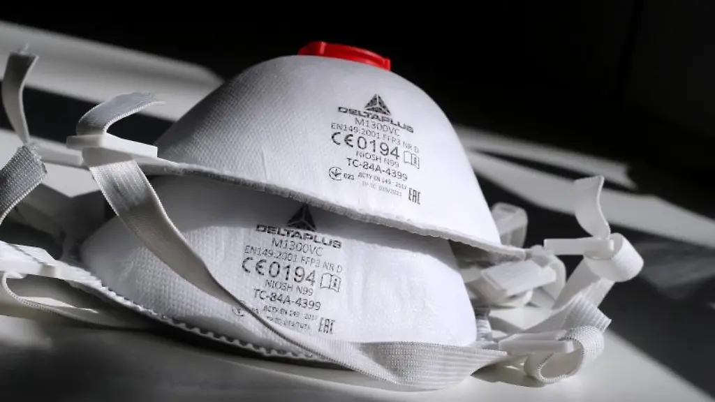 Zwei-FFP3-Atemschutzmasken-liegen-auf-einem-Tisch-im-Sonnenschein