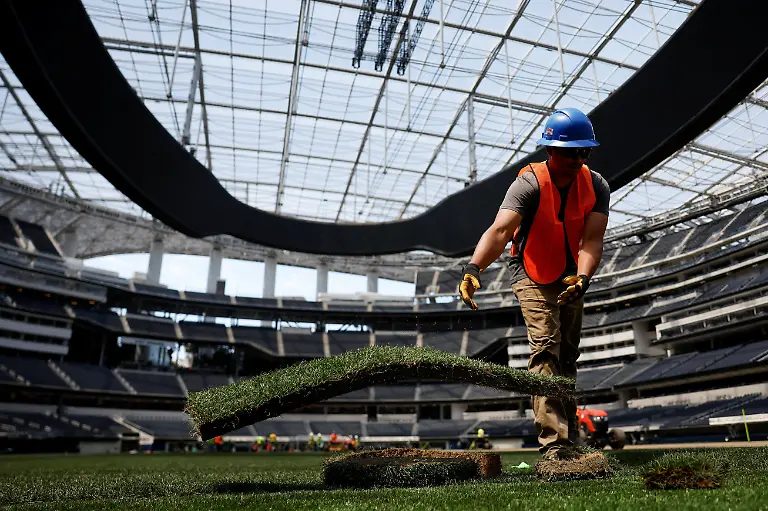 A-worker-installs-a-patch-of-grass-to-be-used-as-part-of-the-pitch-at-SoFi-Stadium-ahead-of-the-FIFA-World-Cup-soccer-tournament-in-Inglewood-California-U-S-May-13-2026