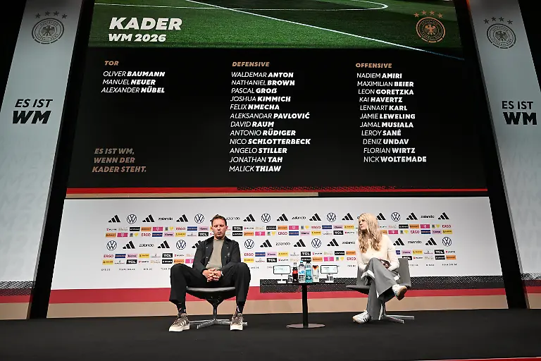 21-05-2026-Hessen-Frankfurt-Fussball-Nationalmannschaft-Bundestrainer-Julian-Nagelsmann-l-und-DFB-Pressesprecherin-Franziska-Wuelle-sitzen-bei-der-Pressekonferenz-zur-Bekanntgabe-des-deutschen-Kaders-fuer-die-Fussball-Weltmeisterschaft-2026-in-Kanada-Mexiko-und-den-USA-auf-der-Buehne-Auf-einer-Leinwand-im-Hintergrund-ist-der-WM-Kader-der-deutschen-Fussball-Nationalmannschaft-zu-sehen-Das-Turnier-findet-vom-11-Juni-bis-19-Juli-2026-statt