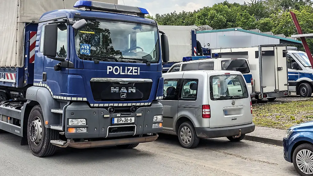 Fahrzeuge-der-Bundespolizei-stehen-auf-einer-Strasse-in-Ahlen-Ermittler-aus-mehreren-europaeischen-Laendern-haben-Objekte-im-Muensterland-durchsucht