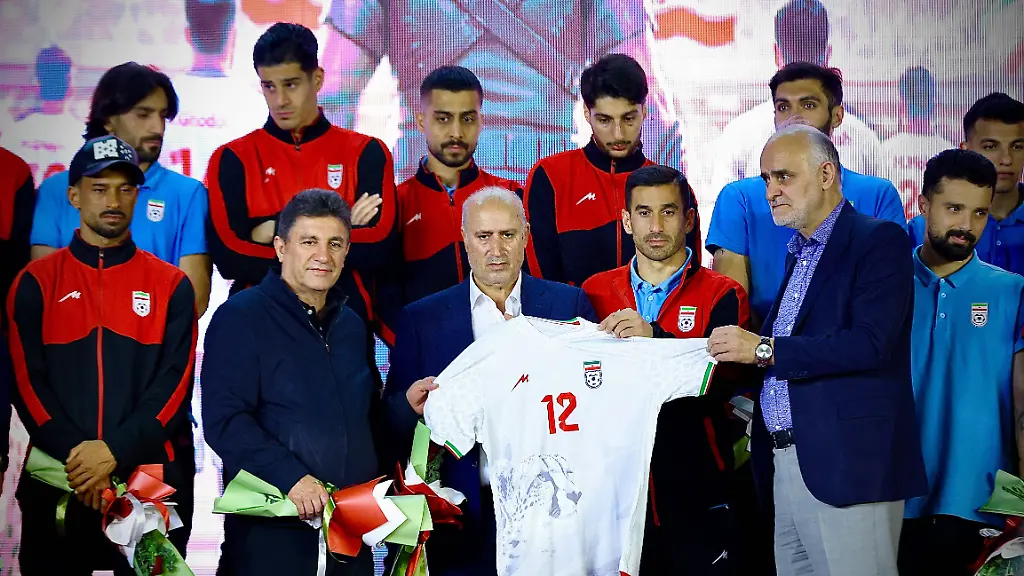 Iran-national-football-team-head-coach-Amir-Ghalenoei-L-and-President-of-the-Football-Federation-Islamic-Republic-of-Iran-Mehdi-Taj-R-hold-up-the-new-team-jersey-on-stage-during-a-ceremony-at-Enqelab-Square-in-Tehran-Iran-on-May-13-2026-The-ceremony-was-organized-to-unveil-the-team-s-new-kit-and-provide-a-public-send-off-from-supporters-ahead-of-the-2026-FIFA-World-Cup