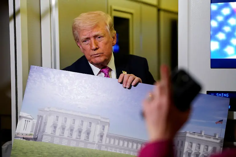 FILE-PHOTO-A-member-of-the-media-raises-her-hand-for-a-question-as-U-S-President-Donald-Trump-talks-while-holding-up-renderings-of-the-planned-White-House-ballroom-aboard-Air-Force-One-en-route-to-Joint-Base-Andrews-Maryland-U-S-March-29-2026