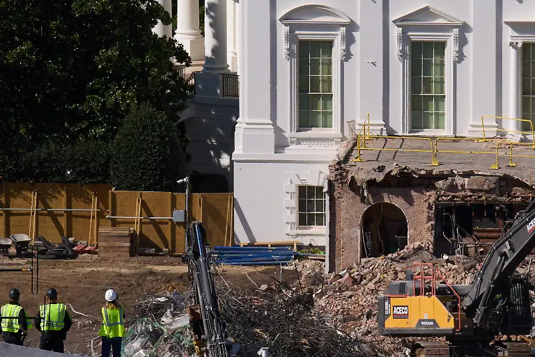 Construction-workers-atop-the-U-S-Treasury-bottom-left-watch-as-work-continues-on-a-largely-demolished-part-of-the-East-Wing-of-the-White-House-Thursday-Oct-23-2025-in-Washington-before-construction-of-a-new-ballroom