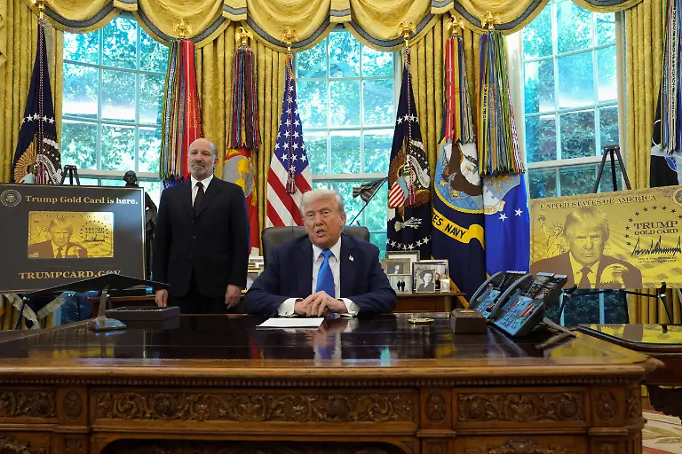 U-S-President-Donald-Trump-looks-on-as-he-sits-next-to-a-sign-that-reads-Trump-Gold-Card-is-here-with-U-S-Secretary-of-Commerce-Howard-Lutnick-standing-by-his-side-in-the-Oval-Office-at-the-White-House-in-Washington-D-C-U-S-September-19-2025-REUTERS-Ken-Cedeno