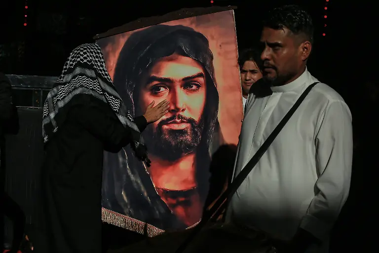 Irakische-schiitische-Muslime-halten-vor-dem-Aschura-Tag-dem-zehnten-Tag-des-Monats-Muharram-in-der-heiligen-Stadt-Karbala-im-Irak-ein-Banner-mit-einem-Portraet-von-Imam-Husain-ibn-Ali-am-Schrein-von-Imam-Abbas-Aschura-gilt-als-Trauerfest-im-schiitischen-Islam