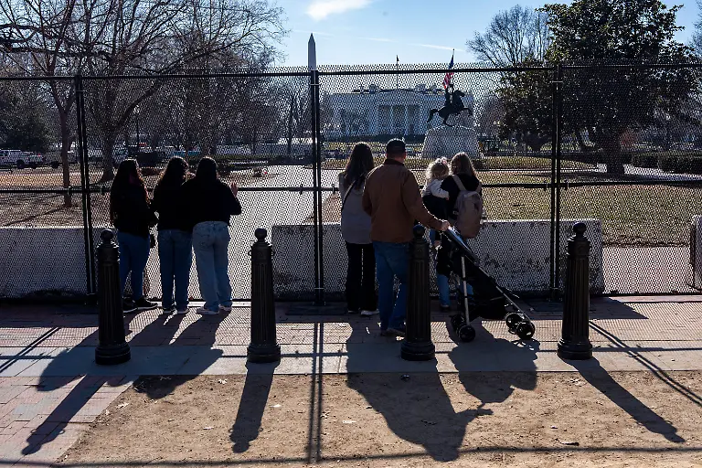 People-look-through-the-fencing-placed-around-Lafayette-Park-near-the-White-House-while-renovations-of-the-park-are-underway-Thursday-Jan-22-2026-in-Washington