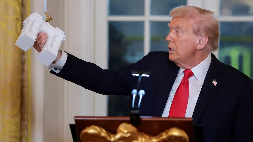 U-S-President-Donald-Trump-holds-a-model-of-an-arch-monument-during-a-ballroom-dinner-in-the-East-Room-at-the-White-House-in-Washington-D-C-U-S-October-15-2025