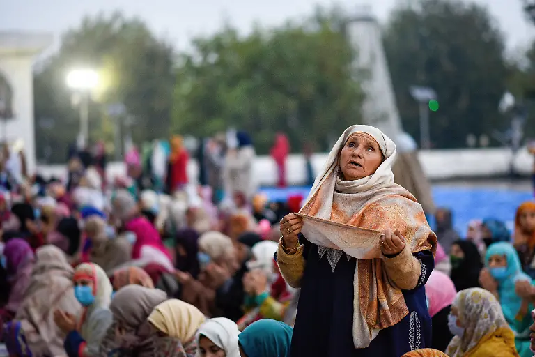 Indien-Muslime-feiern-Maulid-an-Nabi-den-Geburtstag-des-Propheten-Mohammed-in-Srinagar-Kaschmir-October-19-2021-Srinagar-Jammu-and-Kashmir-India-A-Kashmiri-woman-raises-her-hands-while-beseeching-for-blessings-as-the-head-priest-not-framed-displays-a-holy-relic-on-the-eve-of-Eid-Milad-un-Nabi-birth-anniversary-at-Hazratbal-Shrine-in-Srinagar-Thousands-of-Muslim-devotees-gathered-at-the-Hazratbal-shrine-in-the-summer-capital-Srinagar-which-houses-a-relic-believed-to-be-a-hair-from-the-beard-of-Prophet-Muhammed-to-offer-special-prayers-on-the-occasion-of-the-Eid-e-Milad-un-Nabi-the-birth-anniversary-of-Islamic-Prophet-Muhammad