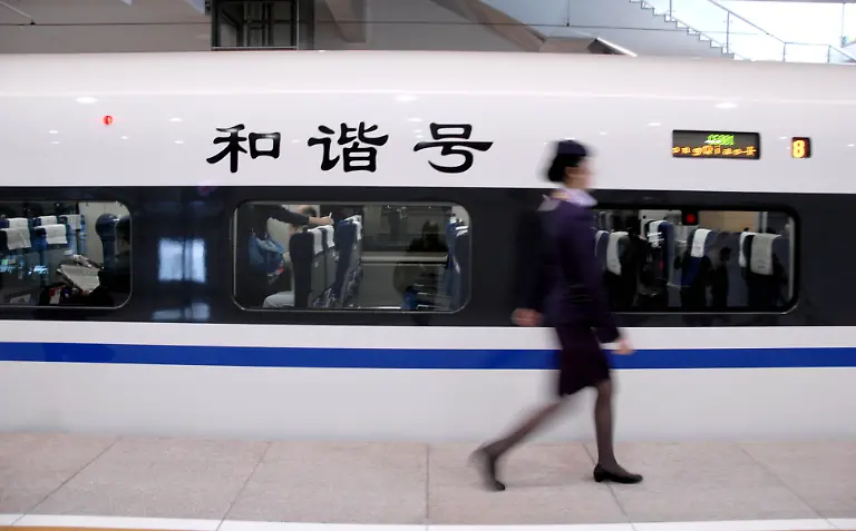 SHANGHAI-CHINA-OCTOBER-26-CHINA-OUT-An-attendant-walks-pass-the-CRH380A-high-speed-train-at-Shanghai-Hongqiao-Station-of-Shanghai-Hangzhou-High-speed-railway-on-October-26-2010-in-Shanghai-China-Trains-on-the-line-will-travel-at-an-average-speed-of-350-kilometers-per-hour-shortening-the-trip-between-to-45-minutes-from-78-minutes