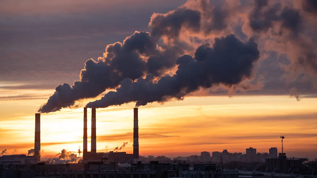 Rauch-aus-der-Fabrik-Rohr-der-Waermestation-in-der-Stadt-in-der-Winterzeit-bei-Sonnenuntergang-Heizoel-oder-Erdgaskraftwerk-Luftverschmutzung-Kamine-Oekologie-Heizsaison-Konzept