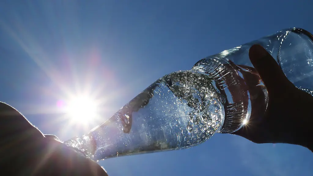 Bayern-Kempten-Eine-Frau-trinkt-im-Sonnenschein-aus-einer-Flasche-sprudelndes-Mineralwasser
