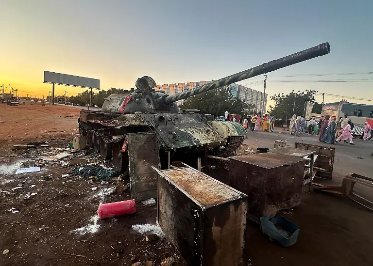People-stand-near-a-tank-after-Sudan-s-army-entered-Wad-Madani-in-Sudan-January-12-2025
