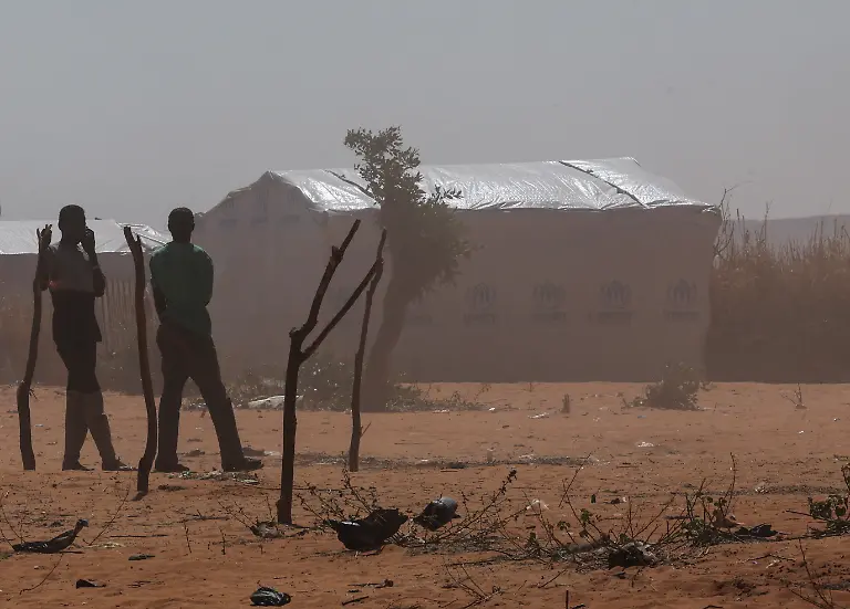 Sudanese-refugee-men-from-Darfur-walk-through-a-sandstorm-at-the-Touloum-refugee-camp-amid-ongoing-conflict-in-their-country-on-the-outskirts-of-the-town-of-Iriba-in-Wadi-Fira-province-eastern-Chad-November-30-2025