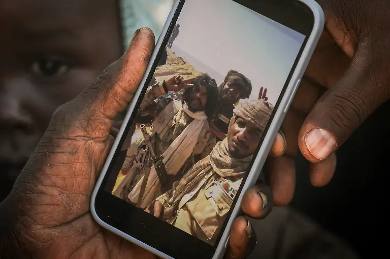 Khadija-Isa-35-a-Sudanese-refugee-from-Al-Fashir-holds-a-smartphone-displaying-a-video-shown-to-her-by-a-Reuters-reporter-in-which-she-recognised-RSF-commander-al-Fateh-Abdullah-Idris-known-as-Abu-Lulu-at-the-Tine-transit-camp-in-eastern-Chad-November-23-2025