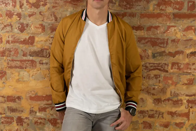 Front-view-mid-section-of-a-young-Caucasian-man-wearing-casual-street-fashion-clothes-standing-against-a-brick-wall-Modellfreigabe-vorhanden