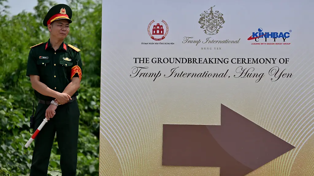 A-military-officer-stands-next-to-a-sign-at-the-groundbreaking-ceremony-for-the-Trump-International-Hung-Yen-resort-and-golf-course-project-in-Hung-Yen-province-on-May-21-2025-US-President-Donald-Trump-s-real-estate-group-broke-ground-on-a-1-5-billion-luxury-resort-and-golf-course-project-close-to-Hanoi-on-May-21-an-AFP-reporter-saw